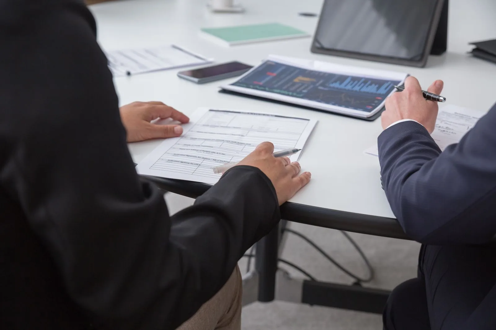 Two colleagues reviewing a data dashboard together at a desk
