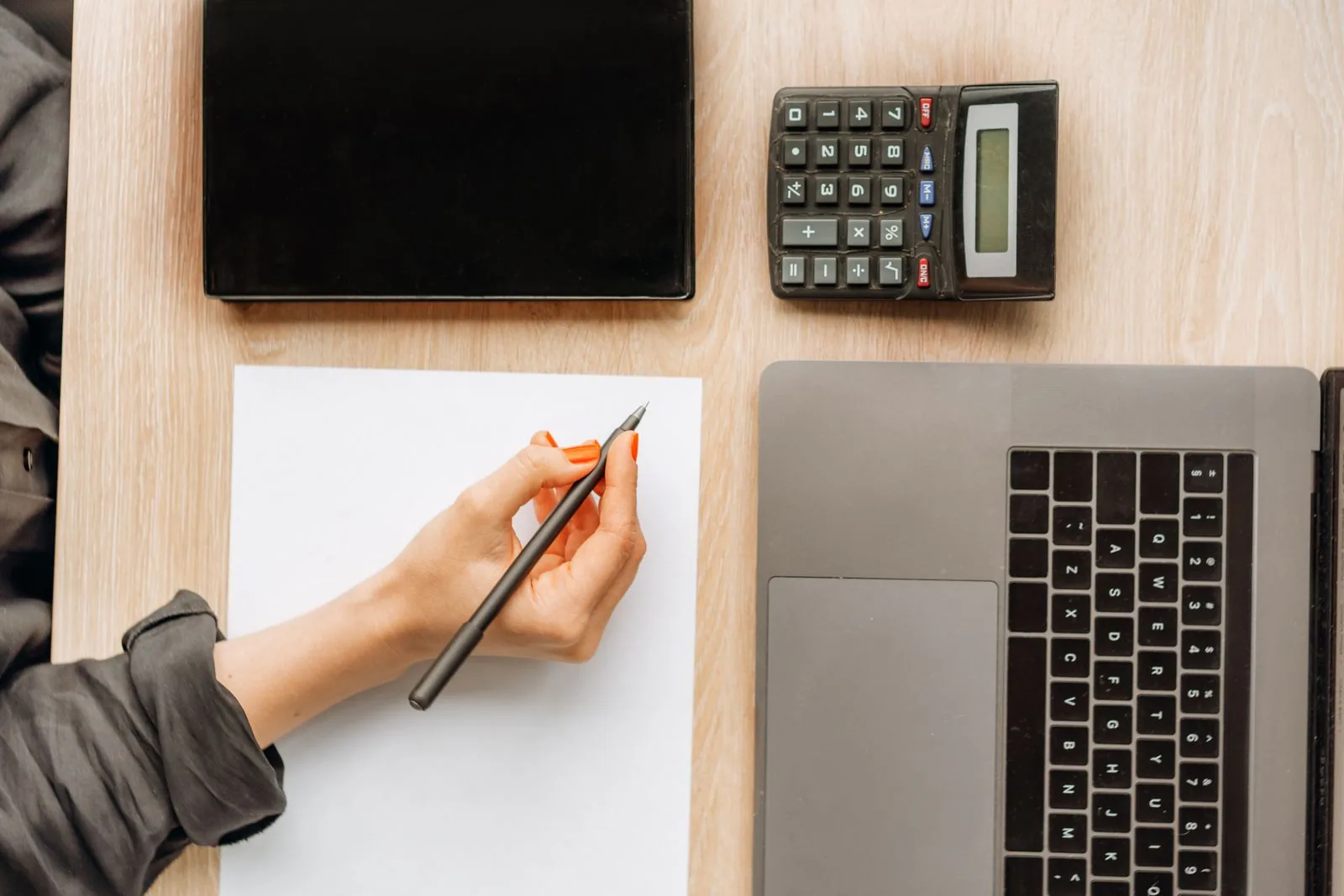 Desk with a laptop, tablet and calculator used for financial administration
