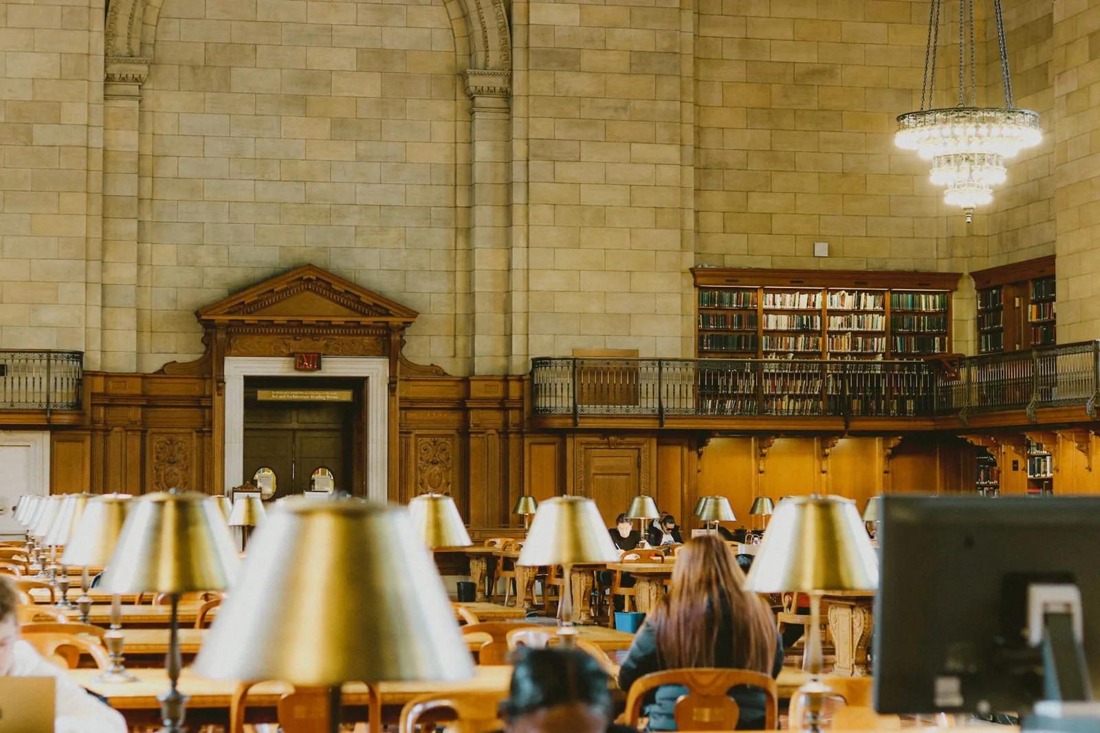 A university library reading room with lamps along long study desks