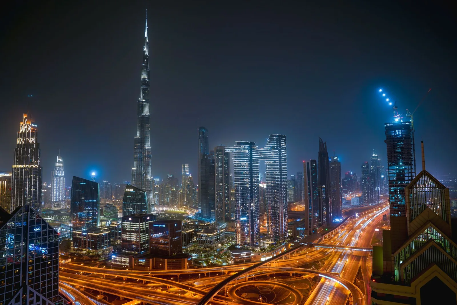 The Dubai skyline at night with the Burj Khalifa and lit highways below